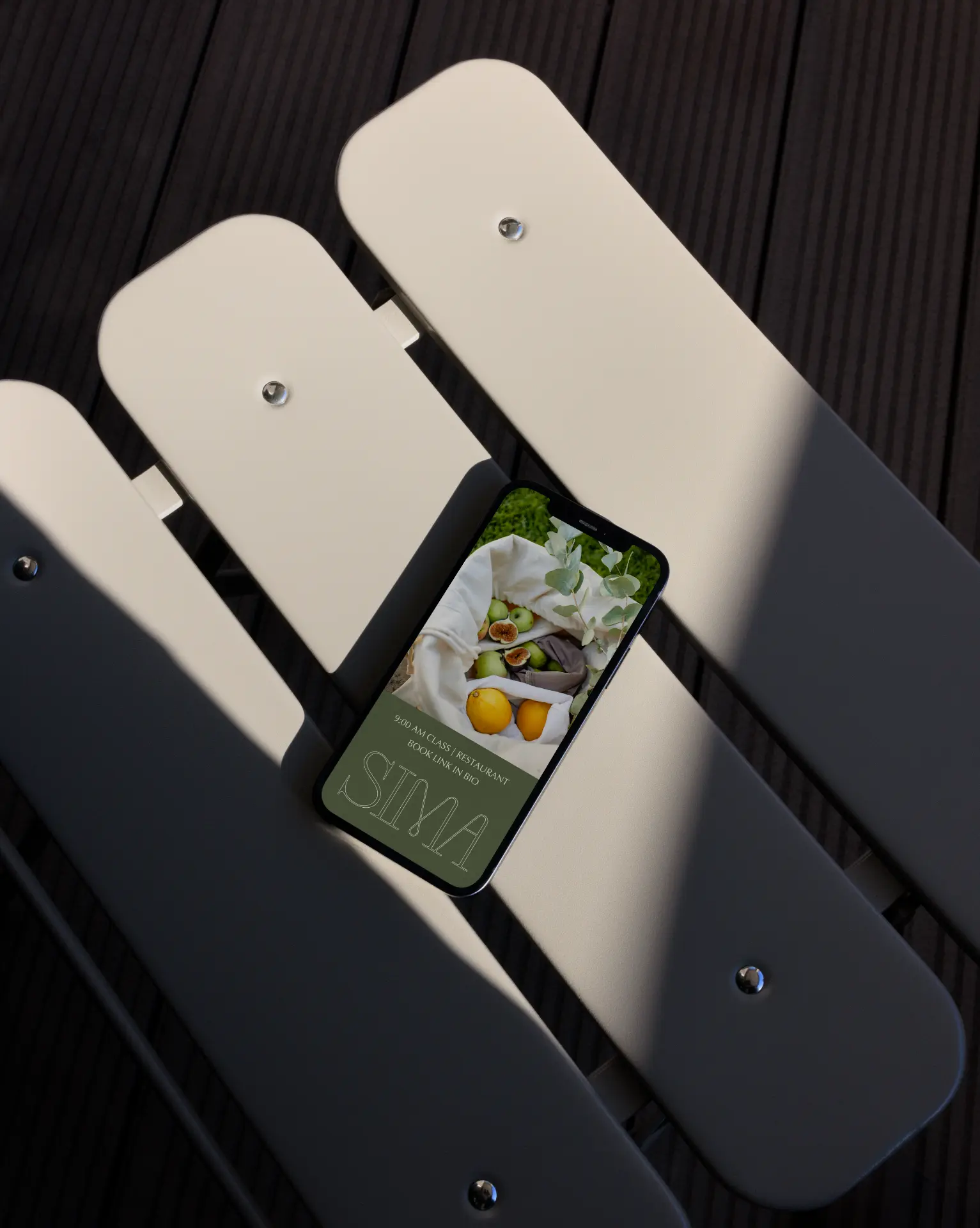 A phone showing the SIMA Club Instagram account on sculptural seating